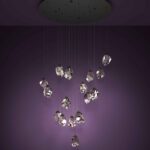 Lustra cu cristale Sindicat Eglo 390413 în ambient modern, cu cele 17 surse LED suspendate de o carcasă neagra, montată pe tavan cu lumina aprinsă.