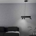 Lustra Bruscoli Eglo 390053 este prezentată cu lumina aprinsă într-un decor cu perete texturat gri, unde spoturile orientabile oferă iluminare directă pe zona canapelei.